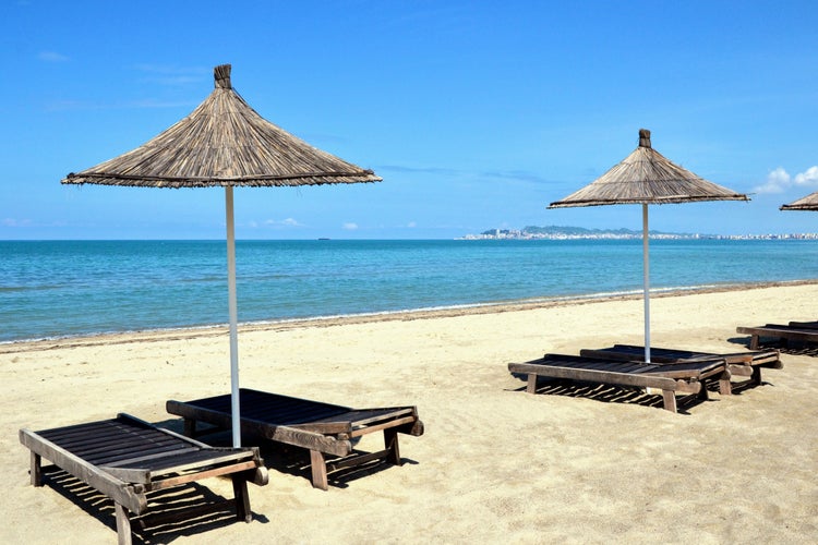 Umbrella and chaise lounges on white sand beach in Durres ,Albania.