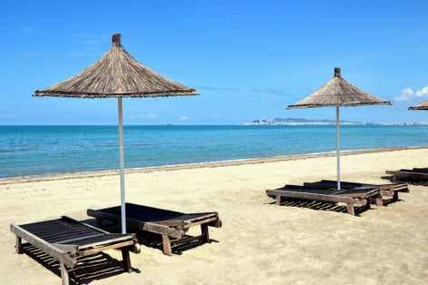 Umbrella and chaise lounges on white sand beach in Durres ,Albania.