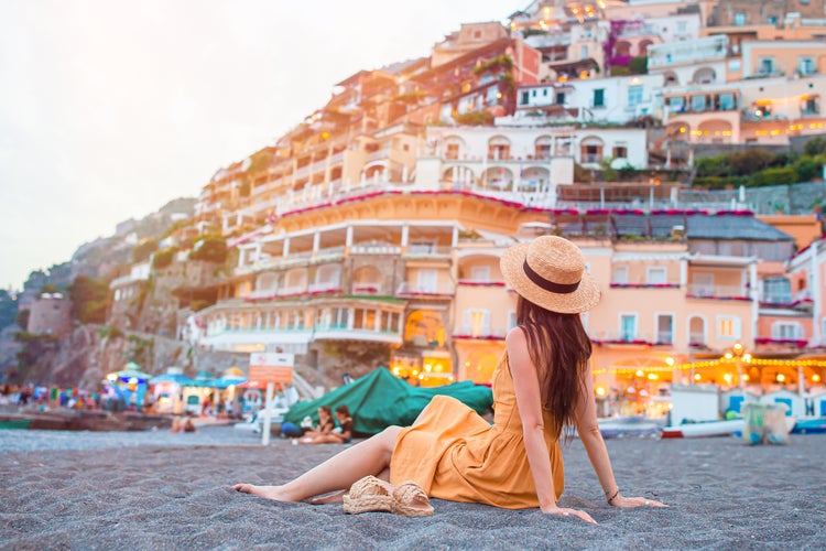 Photo of woman in hat in Positano beach on Amalfi Coast, Italy.