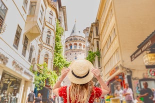 Touristic sightseeing ships in Golden Horn bay of Istanbul and mosque with Sultanahmet district against blue sky and clouds. Istanbul, Turkey during sunny summer day.