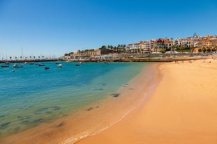 Photo of aerial view over People Crowd Having Fun On Beach And Over Cascais City In Portugal.