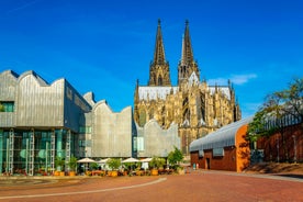 Cologne Aerial view with trains move on a bridge over the Rhine River on which cargo barges and passenger ships ply. Majestic Cologne Cathedral in the background.