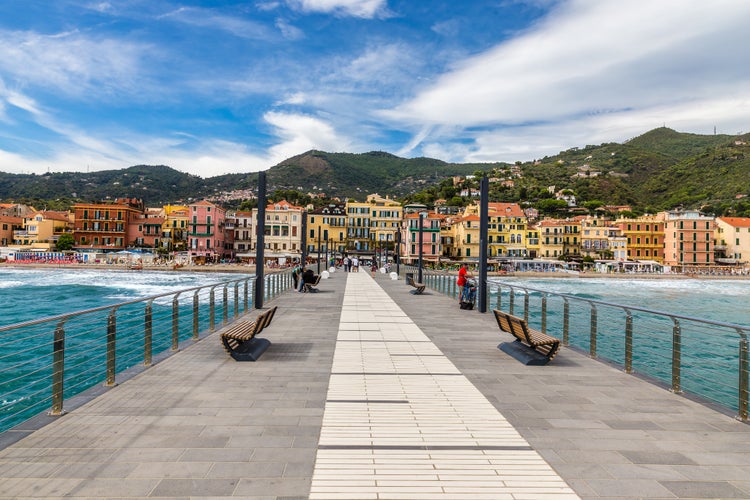 Photo of mole leading to the town of Alassio full of colorful buildings during summer day ,Italy.