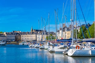 Photo of Vannes, beautiful city in Brittany, boats in the harbor, with typical houses and the cathedral in background, France.