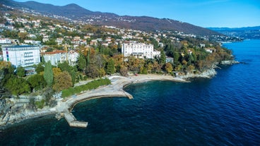 photo of aerial panoramic view of beautiful town of Lovran and sea walkway in Croatia.