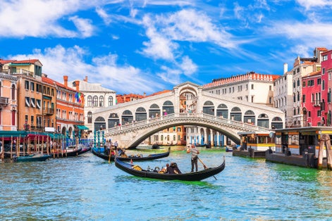 photo of viiew Famous buildings, gondolas and monuments by the Rialto Bridge of Venice on the Grand Canal, Italy.