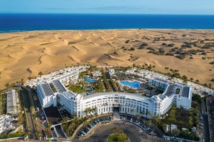 photo of landscape with Maspalomas town and golden sand dunes at sunrise, Gran Canaria, Canary Islands, Spain.