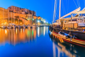 Photo of aerial view from the walls of the citadel of Calvi on the old town with historic buildings and bay with yachts and boats, Corsica, France.