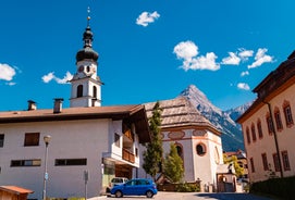 Photo of aerial view of the city of Lermoos, Austria with the Alps mountains in the background on a sunny summer day.