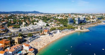 Photo of aerial view over People Crowd Having Fun On Beach And Over Cascais City In Portugal.