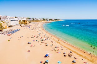 photo of an aerial view of wide sandy beach in touristic resorts of Quarteira and Vilamoura, Algarve, Portugal.