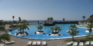 Photo of aerial view with Puerto de la Cruz, in background Teide volcano, Tenerife island, Spain.