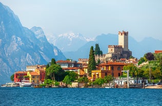 Photo of aerial view of superb Malcesine Mediterranean cityscape with colorful buildings and boats, yachts in the bay, lake Garda, Italy.