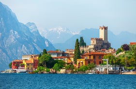 Photo of aerial view of superb Malcesine Mediterranean cityscape with colorful buildings and boats, yachts in the bay, lake Garda, Italy.