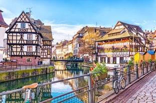 Photo of traditional half-timbered houses on picturesque canals in La Petite France in the medieval fairytale town of Strasbourg, France.