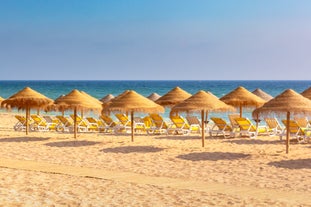 Photo of wide sandy beach in white city of Albufeira, Algarve, Portugal.