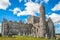 Photo of Ruins of the medieval old huge cathedral among tombstones on Rock of Cashel, Ireland.