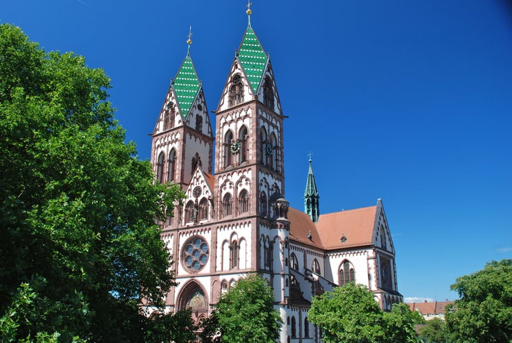 photo of Jesus Sacred Heart Church in Freiburg in Breisgau, Germany. It is a catholic church with a polychrome exterior and it was built with a double tower imitating the cathedral in Limburg.