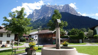 Photo of a view of the Alps from the Ehrwald, a town on the border of Germany and Austria with picturesque meadows surrounded by towering mountain ranges, including the Zugspitze.