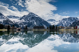 photo of beautiful snow capped mountains with Arosa village in France. Back country skier in the foreground leave their tracks in the deep snow.