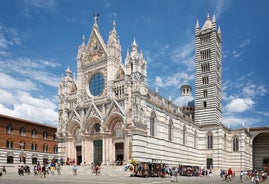 Photo of Italy Piazza Maggiore in Bologna old town tower of town hall with big clock and blue sky on background, antique buildings terracotta galleries.