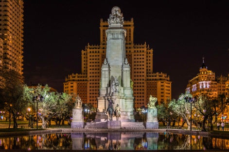 Photo of Monument to Miguel de Cervantes reflected in the water, in the Plaza de España in Madrid.