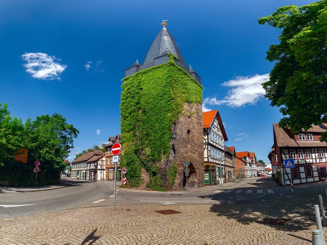 Westerntor Tower in Wernigerode, Germany, is a historic medieval tower covered in ivy, situated at a key intersection in the town