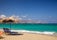 Photo of blue sun loungers with parasol on Ammoudara beach, Greece.