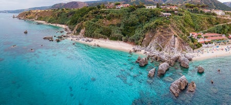 photo of an aerial view of Parghelia in Italy. Overview of seabed seen from above, transparent water and beach with umbrellas.