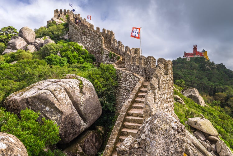 Photo of Castle of the Moors wall with Pena National Palace in the distance, Sintra, Portugal.