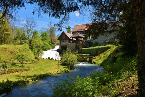 photo of view of Buildings in the town of Slunj in Karlovac county, Croatia with a stream flowing next to the buildings