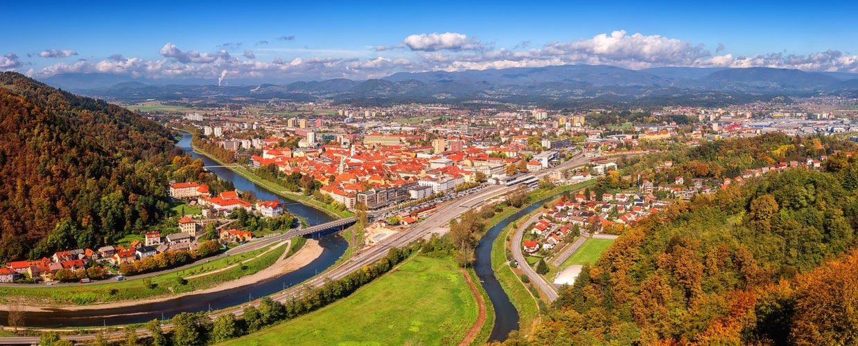 Large panorama of Celje city in Slovenia, aerial view from old castle ancient walls. Amazing landscape with town in Lasko valley, river Savinja and blue sky with clouds, outdoor travel background