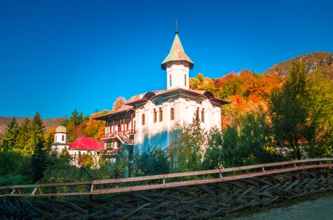 Photo of Turnu Monastery, Cozia Mountain, Romania. The monastery is located near Calimanesti Caciulata, Valcea county. It is surrounded by a wood fence. The photo was taken in autumn.