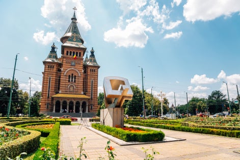 Photo of Victory Square with the Orthodox Cathedral, Timisoara is a long square with green park surrounded by national opera on one side and the metropolitan cathedral on the other.