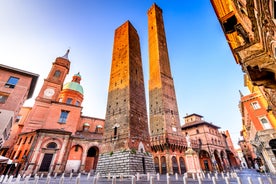 Photo of Italy Piazza Maggiore in Bologna old town tower of town hall with big clock and blue sky on background, antique buildings terracotta galleries.