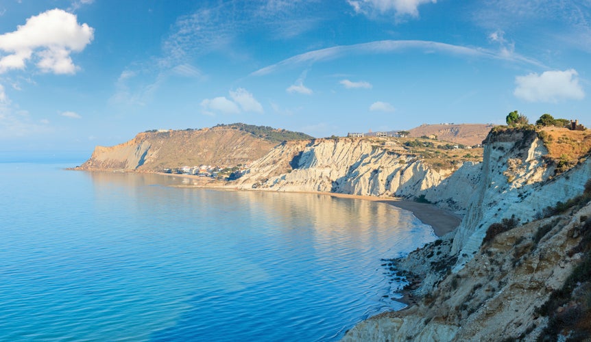 Photo of sandy beach under famed white cliff, called "Scala dei Turchi", in Sicily, near Agrigento, Italy.