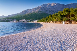 Photo of panorama and landscape of Makarska resort and its harbour with boats and blue sea water, Croatia.