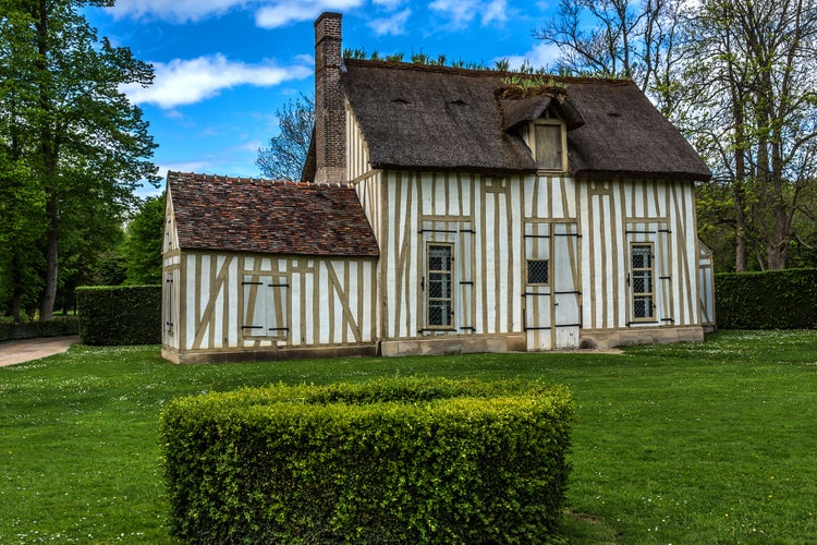 Photo of Ancient Half-timbered house in Chantilly Garden. Famous Chateau de Chantilly (Chantilly Castle, 1560) - historic chateau, town of Chantilly, Oise, Picardie, France.