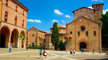 Photo of Italy Piazza Maggiore in Bologna old town tower of town hall with big clock and blue sky on background, antique buildings terracotta galleries.