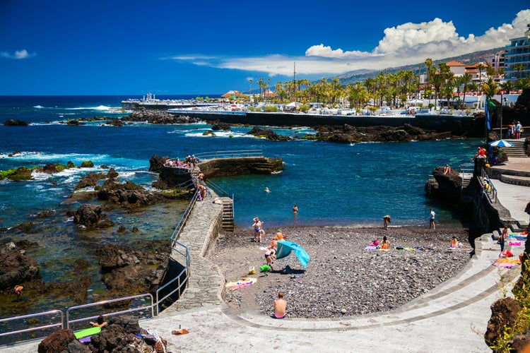 people enjoy the good weather on the beach of San Telmo in Puerto de la Cruz, Tenerife, Spain