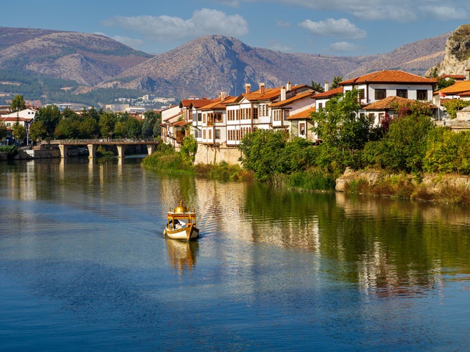 a boat on the river and historical ottoman houses by the river in Amasya