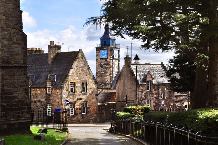 Photo of Historic old buildings with stepped gable roofs and Tolbooth tower in the distance. Stirling, Scotland.