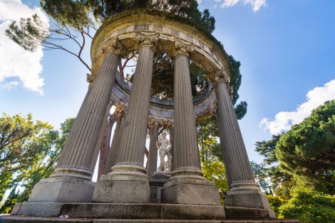 Photo of Small roman style temple with a goddess statue inside, sited at the "El Capricho" public park, in Madrid, Spain .