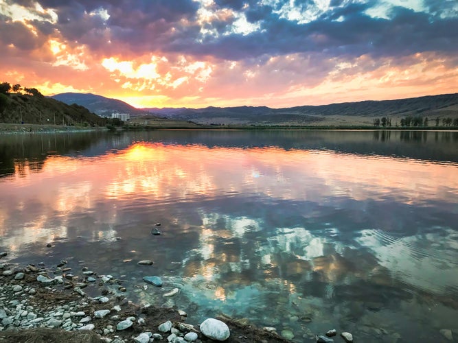 photo of Lisi lake panorama with reflections of dramatic sky and sunset over the horizon. Lakes and leisure in Tbilisi, Georgia.