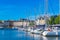 Photo of Vannes, beautiful city in Brittany, boats in the harbor, with typical houses and the cathedral in background, France.