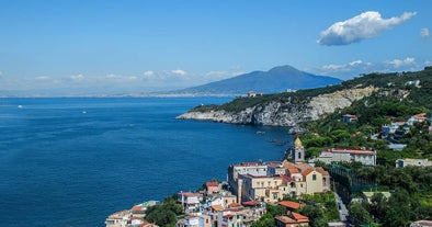 Naples, Italy. View of the Gulf of Naples from the Posillipo hill with Mount Vesuvius far in the background and some pine trees in foreground.