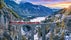 photo of aerial view of Train passing through famous mountain in Filisur, Switzerland. Landwasser Viaduct world heritage with train express in Swiss Alps snow winter scenery.