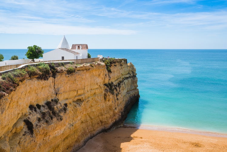 Photo of the Chapel of Nossa Senhora da Rocha on top of the spectacular cliffs on Nova Beach, Porches, Region Algarve, Portugal.