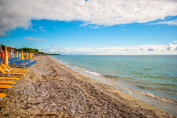 Photo of The sea shore of Leptokarya, with blue sky and clouds and clear sea.