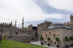 Touristic sightseeing ships in Golden Horn bay of Istanbul and mosque with Sultanahmet district against blue sky and clouds. Istanbul, Turkey during sunny summer day.